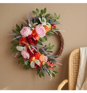 Detailed macro view of the pink and orange peony blossoms and leaves on the wreath.