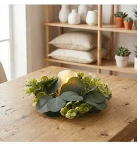 Close-up of an artificial eucalyptus wreath candle holder on a rustic wooden dining table