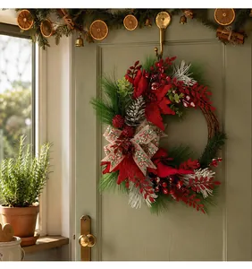 Elegant Christmas wreath with pine branches, red berries and cardinal on a green door