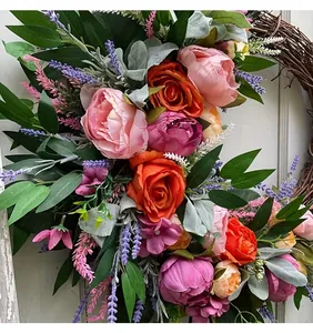 Detailed view of a handmade autumn wreath with vibrant pink and orange silk peonies