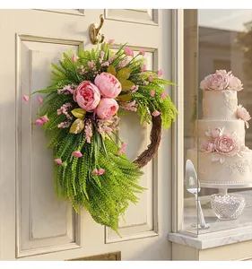 Dettaglio della ghirlanda di peonie rosa appesa alla porta per decorazione domestica