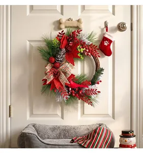 Close-up of a festive Christmas wreath with red berries and a cardinal bird hanging on a white door