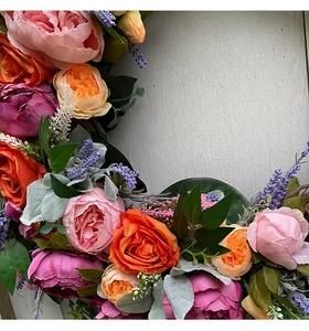 Detailed close-up showing vibrant pink and orange peonies and lavender in a door wreath