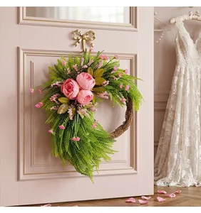 Vista dettagliata di una ghirlanda decorativa di peonie rosa su una porta rosa romantica