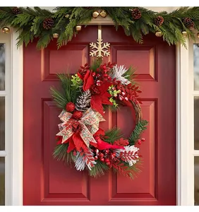 Detailed view of a Christmas pine wreath with red cardinal and berries on a red door.