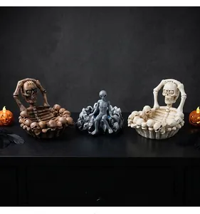 Detailed macro view of Halloween skeleton ashtrays and grey alien figurine on a black table