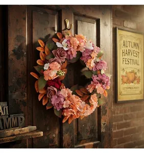 Dettaglio di una ghirlanda autunnale con ortensie e rose su una porta in legno rustico