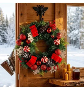 Detail van een kerstkrans met dennenappels, sneeuwvlokken en rode kerstversiering