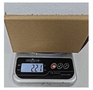 Skull ashtray in packaging box being weighed on a digital scale showing 221 grams