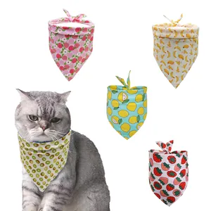 Detail of cotton pet bandana bibs featuring vibrant fruit patterns like strawberry and lemon