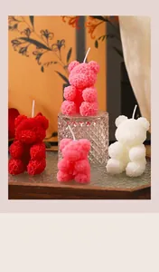 Détail montrant des bougies parfumées en forme d'ours à texture rose sur du verre