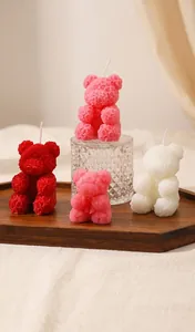 Dettaglio che mostra candele profumate a forma di orso con trama a rosa su vetro