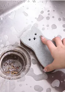 Close-up of a cat-shaped three-layer kitchen cleaning sponge in a stainless sink
