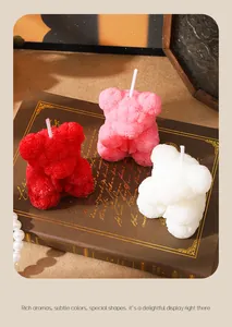 Détail en gros plan de trois bougies ours en roses de couleurs rouge, rose et blanc