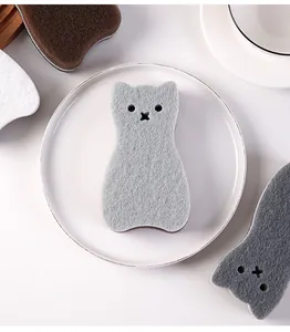 Detailed view of a cute grey cat-shaped 3-layer cleaning sponge on a white ceramic plate