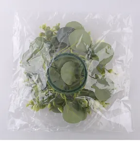 Detailed view of artificial eucalyptus leaf candle ring wreath in plastic packaging