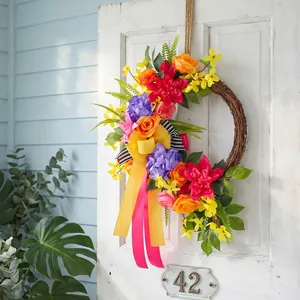 Colorful spring summer floral wreath on rattan base with ribbons for front door decor