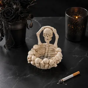 Detailed gothic skeleton ashtray for Halloween home decor on a dark marble surface.