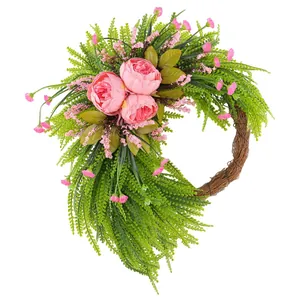 Elegante ghirlanda di peonie rosa artificiali con felci per decorazione murale primaverile.