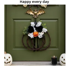 Detail of a Halloween pumpkin vine wreath with black and orange artificial flowers for decor.