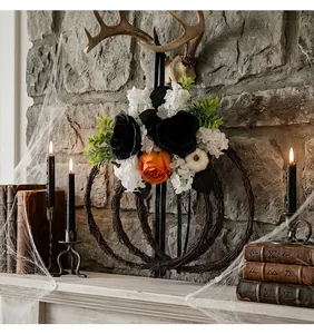 Spooky Halloween floral wreath with black roses and pumpkin on a stone fireplace mantle