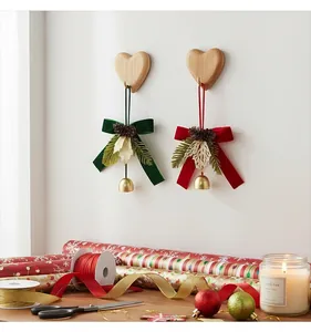 Nœuds de Noël en velours avec cloches suspendus à des crochets cœur dans un décor festif