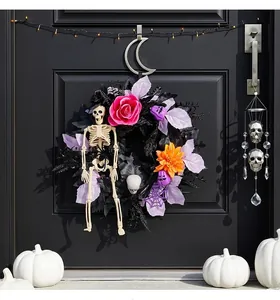 Vista dettagliata di una ghirlanda di scheletri di Halloween con fiori su porta nera.
