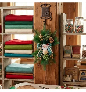Adorno navideño de agujas de pino de Papá Noel colgado en una viga de madera rústica