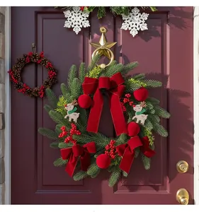 Close-up of festive Christmas wreath with burgundy velvet bows and red berries on a door.