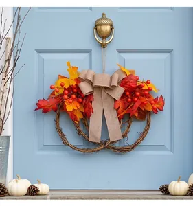 Traditional autumn wreath featuring red maple leaves and berries on a blue door.
