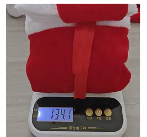 Détail montrant la tenue de Noël légère en velours sur une balance numérique