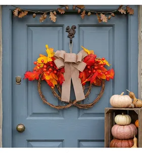 Autumn maple leaf wreath decoration with red berries and burlap bow on a blue door