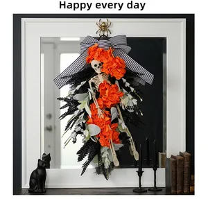 Detail of Halloween skeleton wreath with orange flowers and a black and white striped bow.
