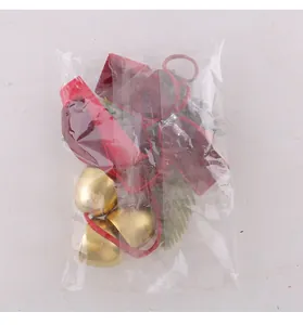 Décoration de nœud de Noël avec cloches dorées sous un emballage plastique protecteur
