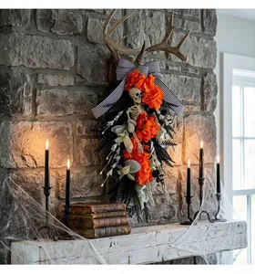 Detailed view of Halloween skeleton swag wreath with orange flowers and striped bow