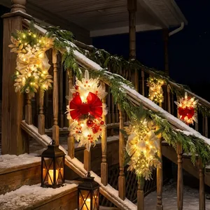 Vertical Christmas teardrop wreaths with warm LED lights on a snowy porch railing