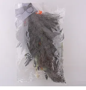 Detailed view of Halloween skull wreath inside its clear protective packaging bag.