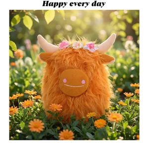 Primo piano di un peluche di mucca scozzese arancione con corona di fiori in un giardino