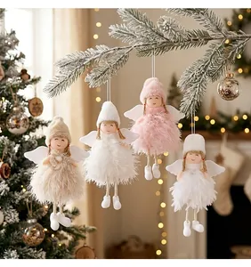 Detailed view of four fluffy feather angel ornaments hanging on a snowy pine branch.
