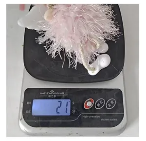 Detailed view of a pink feather Christmas angel ornament weighing 21g on a scale.