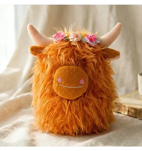 Primo piano di peluche mucca Highland con corona di fiori e consistenza soffice