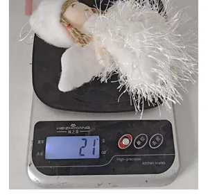 Detailed photo of a white feather Christmas angel ornament weighing 21 grams on a scale