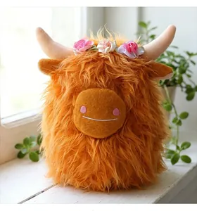 Dettaglio di peluche mucca Highland arancione con corona di fiori e pelliccia folta.