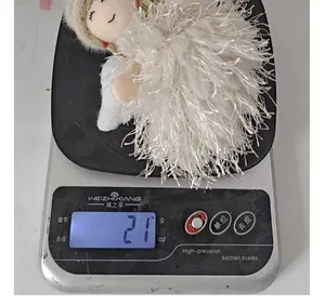 Detailed view of white feather Christmas angel ornament weighing 21g on a scale
