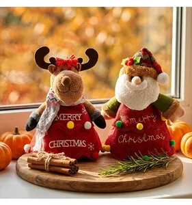 Dettaglio ravvicinato di sacchetti regalo natalizi in peluche con Babbo Natale e renna su legno.