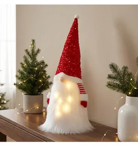 Nahaufnahme eines leuchtenden Weihnachtswichtels mit roten Pailletten und warmweißen LEDs
