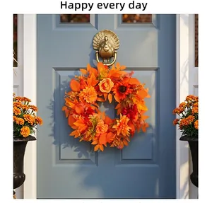 Dettaglio di una ghirlanda autunnale con foglie d'acero arancioni su una porta blu