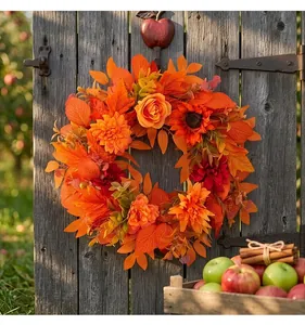 Ghirlanda decorativa per il raccolto autunnale con foglie d'acero arancioni e girasoli su legno