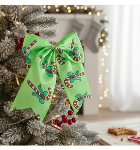 Macro view of a green satin Christmas bow featuring festive candy cane patterns on a tree.