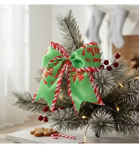 Close-up of festive green Christmas bow with red striped edges on tree branch